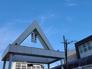 A large concrete triangle with a column of eight bells hanging down inside. This is marks the entrance to one of the many shotengai shopping streets around Hiratsuka